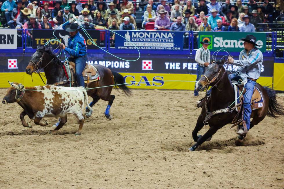 Team ropers Jake Smith and Douglas Rich rope a calf during round three of the National Finals R ...