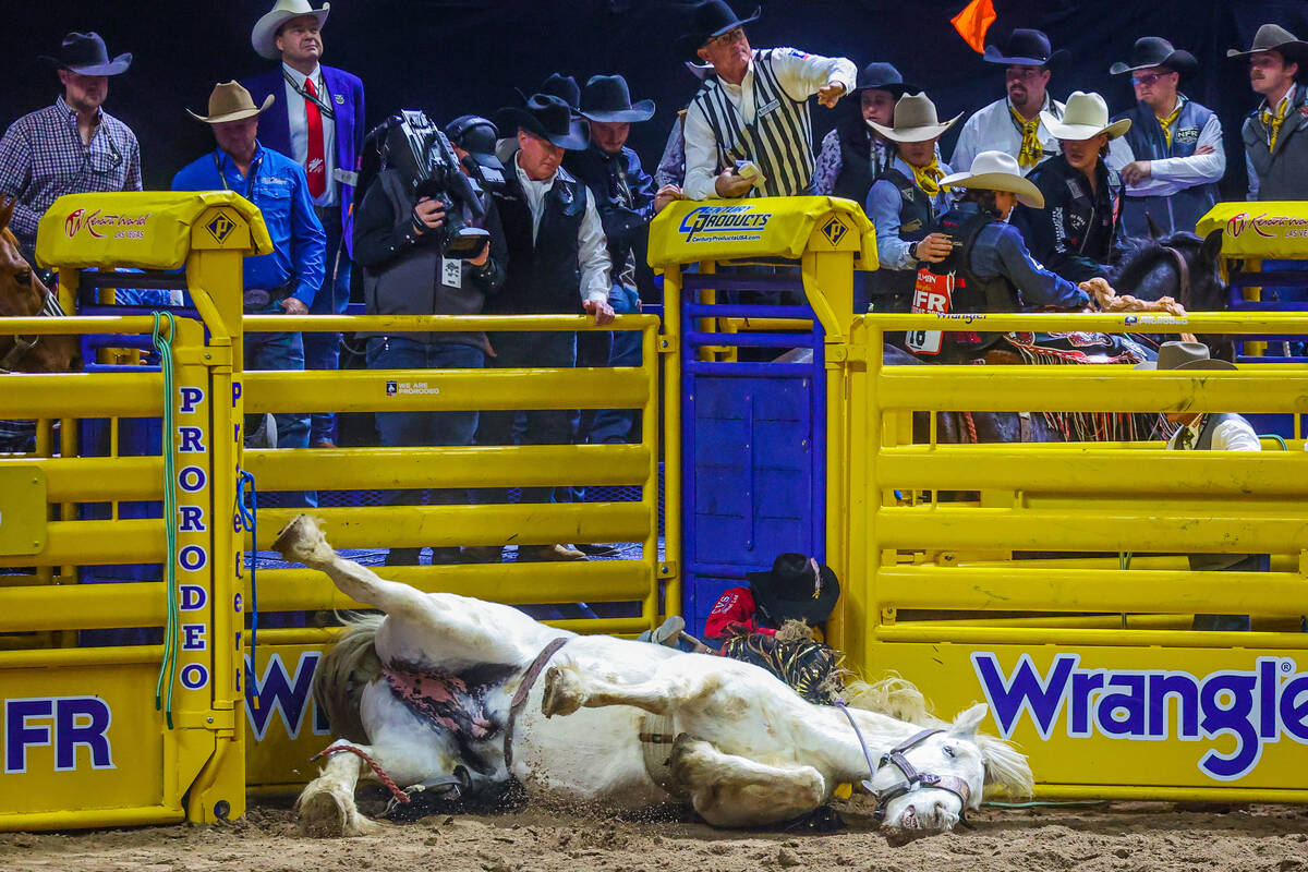 Saddle bronc rider Kolby Wanchuk and Mommas Boy fall into the chute before getting up during ro ...