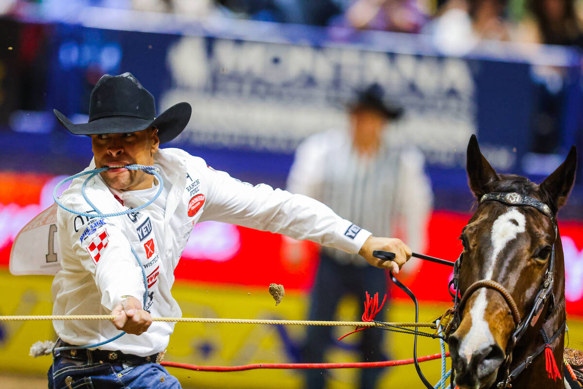 Tie-down roper Shad mayfield runs from his horse to tie down the calf during round four of the ...