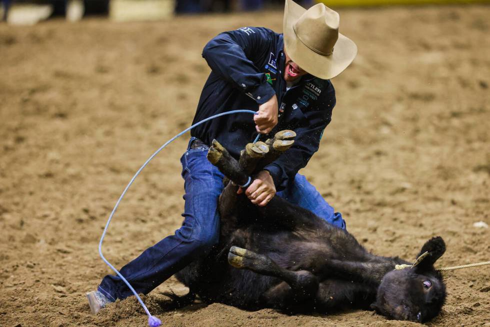 Tie-down roper Hunter Herrin ropes up the calf during round four of the National Finals Rodeo a ...