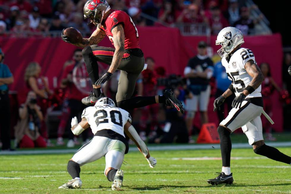 Tampa Bay Buccaneers wide receiver Mike Evans (13) leaps over Las Vegas Raiders safety Isaiah P ...