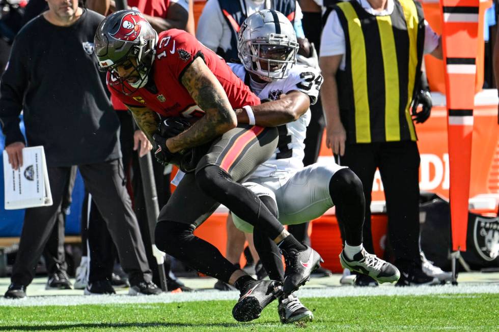 Tampa Bay Buccaneers wide receiver Mike Evans (13) is tackled by Las Vegas Raiders safety Thoma ...