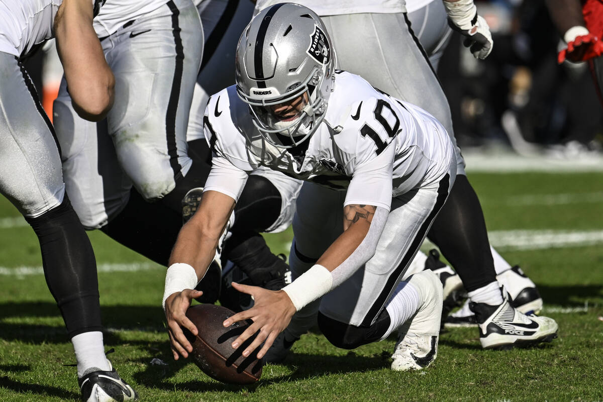 Las Vegas Raiders quarterback Desmond Ridder (10) dives onto his own fumble against the Tampa B ...