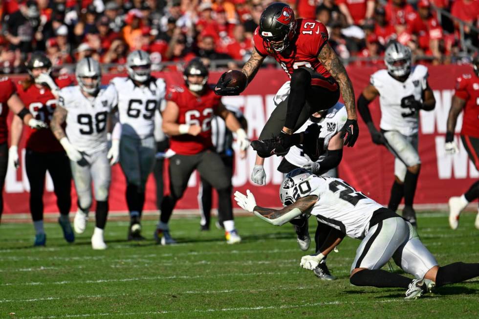 Tampa Bay Buccaneers wide receiver Mike Evans (13) leaps over Las Vegas Raiders safety Isaiah P ...