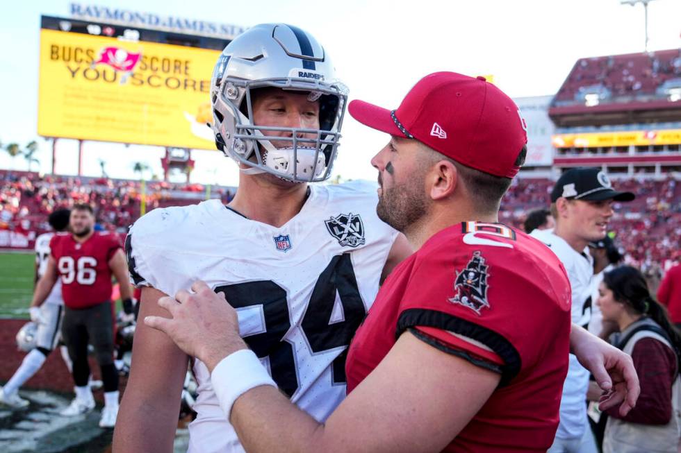 Tampa Bay Buccaneers quarterback Baker Mayfield (6) speaks with Las Vegas Raiders tight end Har ...