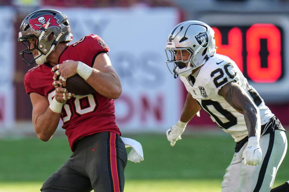 Tampa Bay Buccaneers tight end Cade Otton (88) runs past Las Vegas Raiders safety Isaiah Pola-M ...