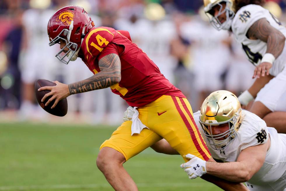 Southern California quarterback Jayden Maiava, left, is sacked by Notre Dame defensive lineman ...