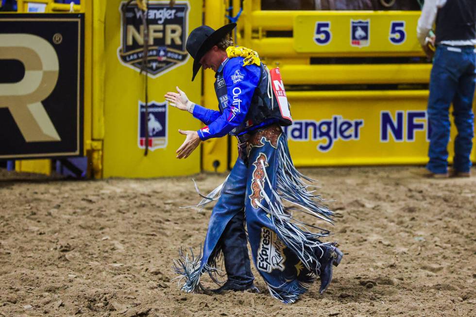 Saddle bronc rider Ryder Wright claps after hearing his score for his ride on Tickled Pink duri ...