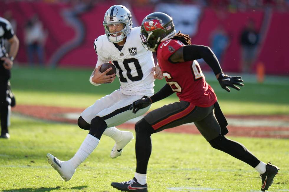 Las Vegas Raiders quarterback Desmond Ridder (10) tries to get around Tampa Bay Buccaneers safe ...