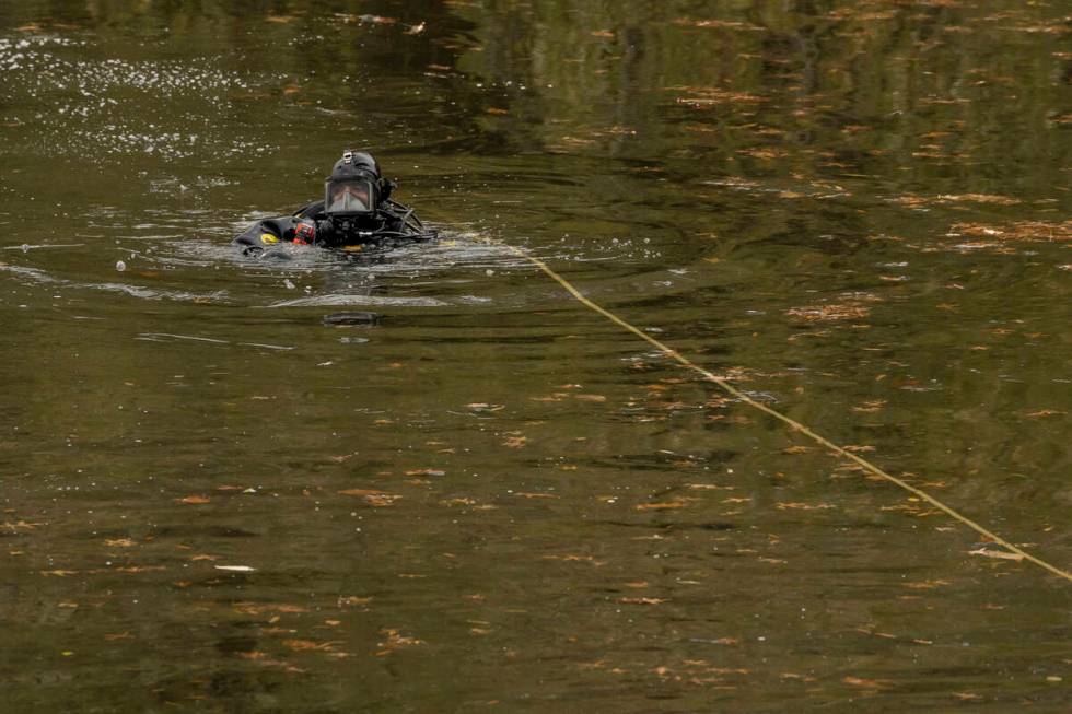 NYPD officers in diving suits search a lake in Central Park, Monday, Dec. 9, 2024, in New York. ...