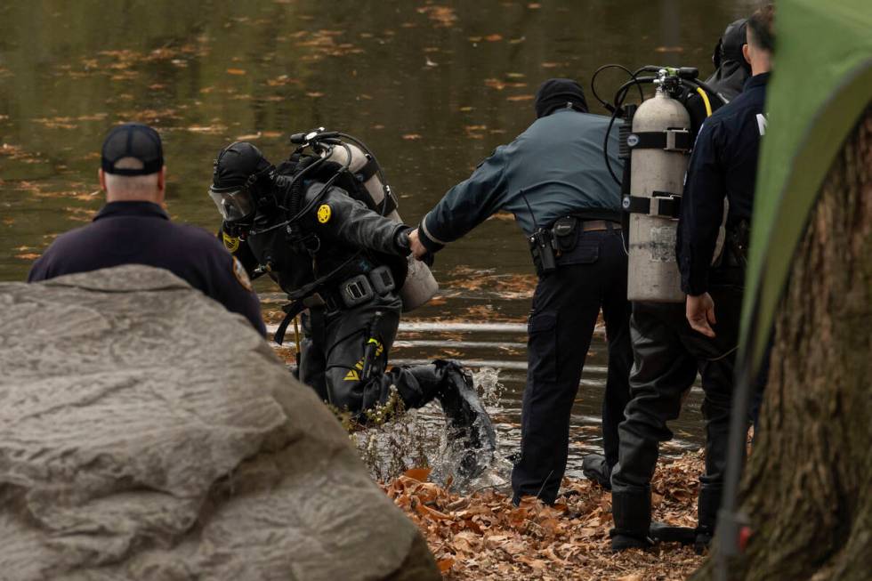 NYPD officers in diving suits search a lake in Central Park, Monday, Dec. 9, 2024, in New York. ...