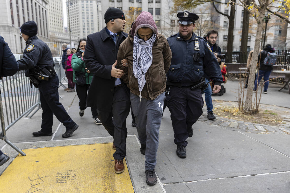 A person protesting the not guilty verdict of Daniel Penny is arrested by police outside the cr ...