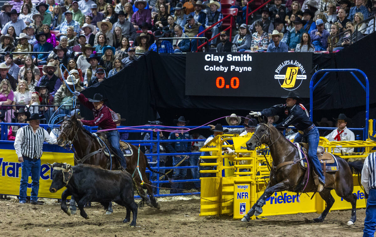 Team Roping header Clay Smith, right, and heeler Coleby Payne work to rope their calf during Na ...