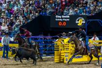 Team Roping header Clay Smith, right, and heeler Coleby Payne work to rope their calf during Na ...