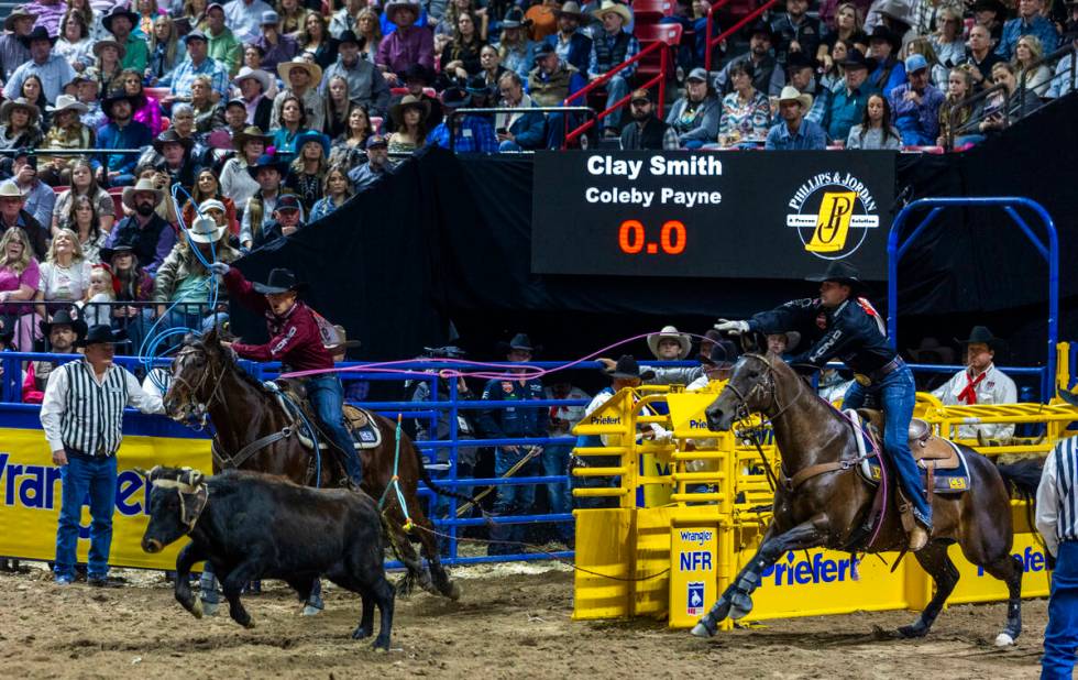 Team Roping header Clay Smith, right, and heeler Coleby Payne work to rope their calf during Na ...