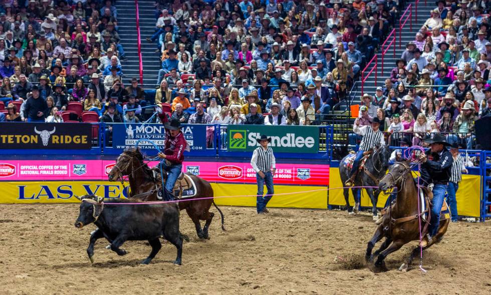 Team Roping header Clay Smith, right, and heeler Coleby Payne work to rope their calf during Na ...