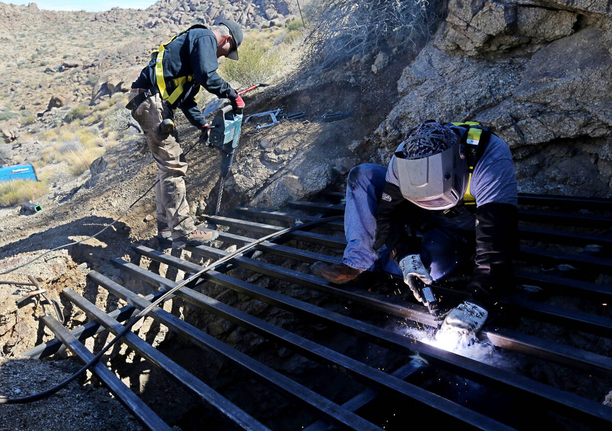 State contractors Brian Breiter, left, and James Ryan secure steel across the opening of an aba ...