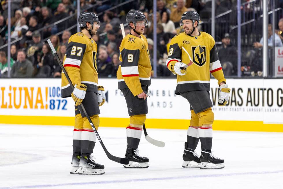 Golden Knights defenseman Shea Theodore (27) and center Jack Eichel (9) listen to center Tomas ...