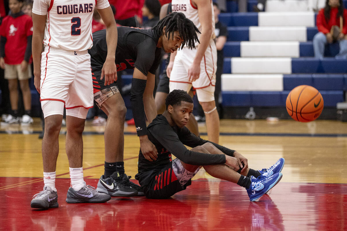 Las Vegas junior Tre Smith, left, begins to help up senior Tayshaun Jackson, right, during the ...