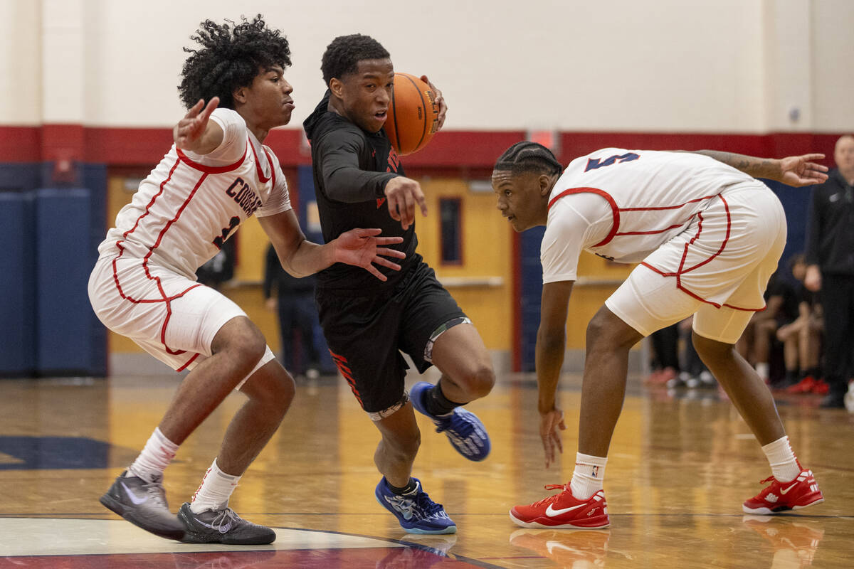 Las Vegas senior Tayshaun Jackson, center, attempts to rush past Coronado senior Jalen St. Clai ...