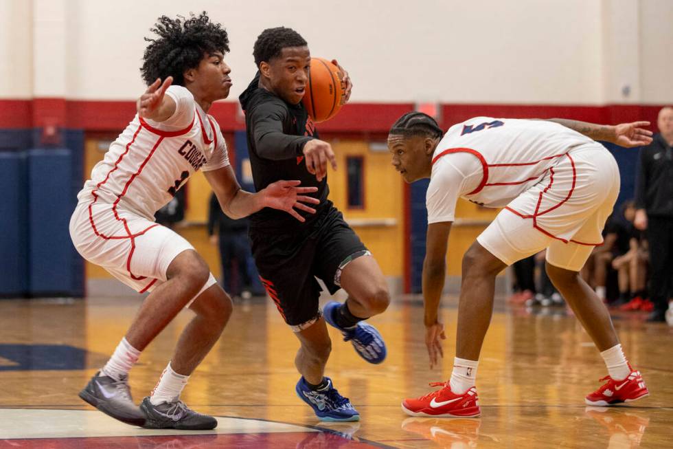 Las Vegas senior Tayshaun Jackson, center, attempts to rush past Coronado senior Jalen St. Clai ...