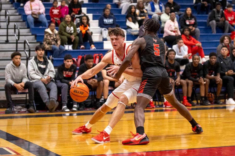 Coronado senior JJ Buchanan, left, attempts to dribble around Las Vegas junior Jakhai Jones (5) ...