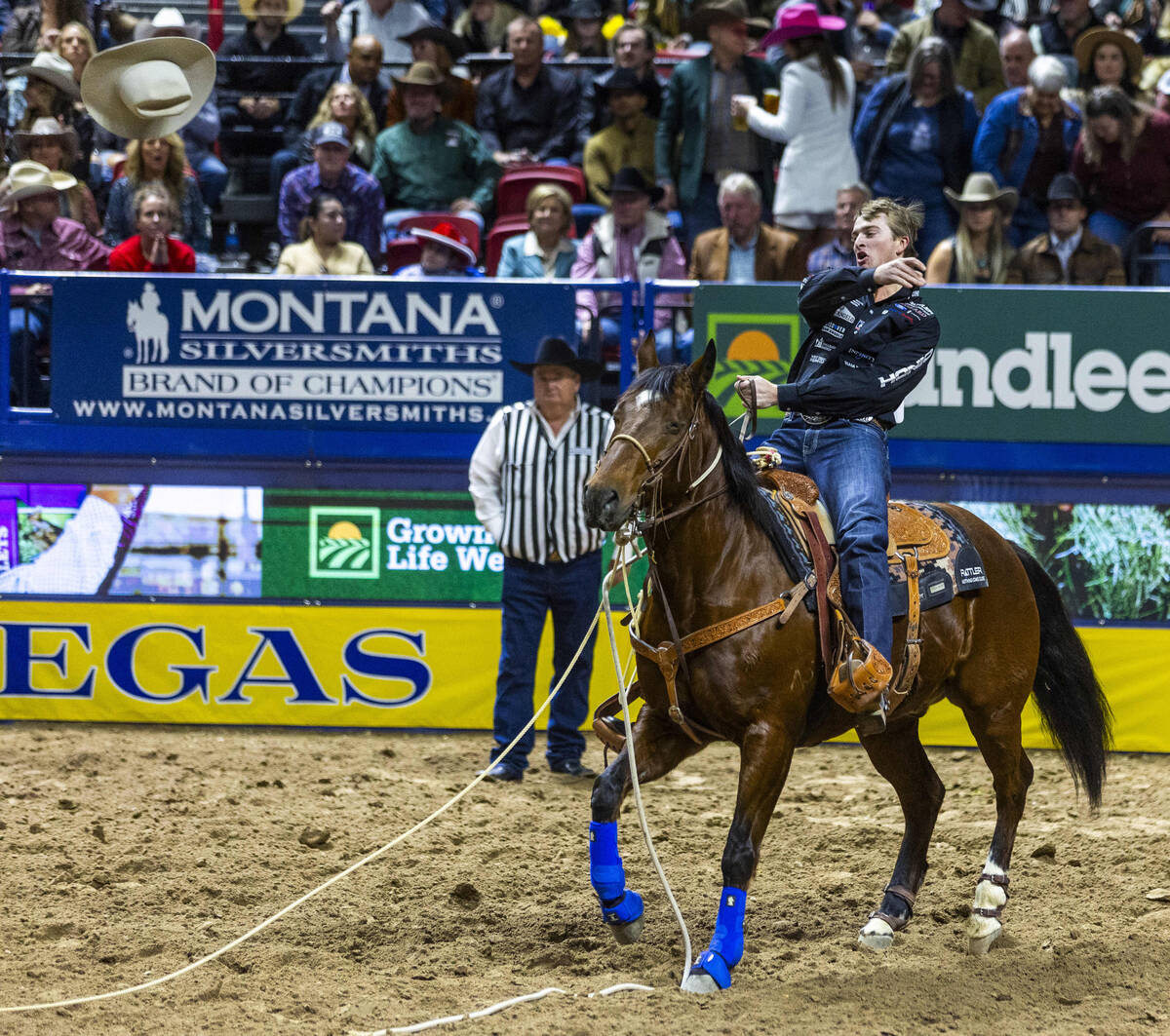 Tie-Down Roping contestant Dylan Hancock tosses his hat in celebration of a winning time during ...