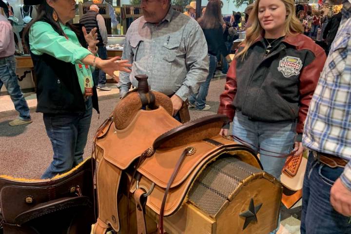 Circle Y Saddles' Jill Hollomon, left, helps Tony Ericksen, Brenna Williams and Colton Williams ...