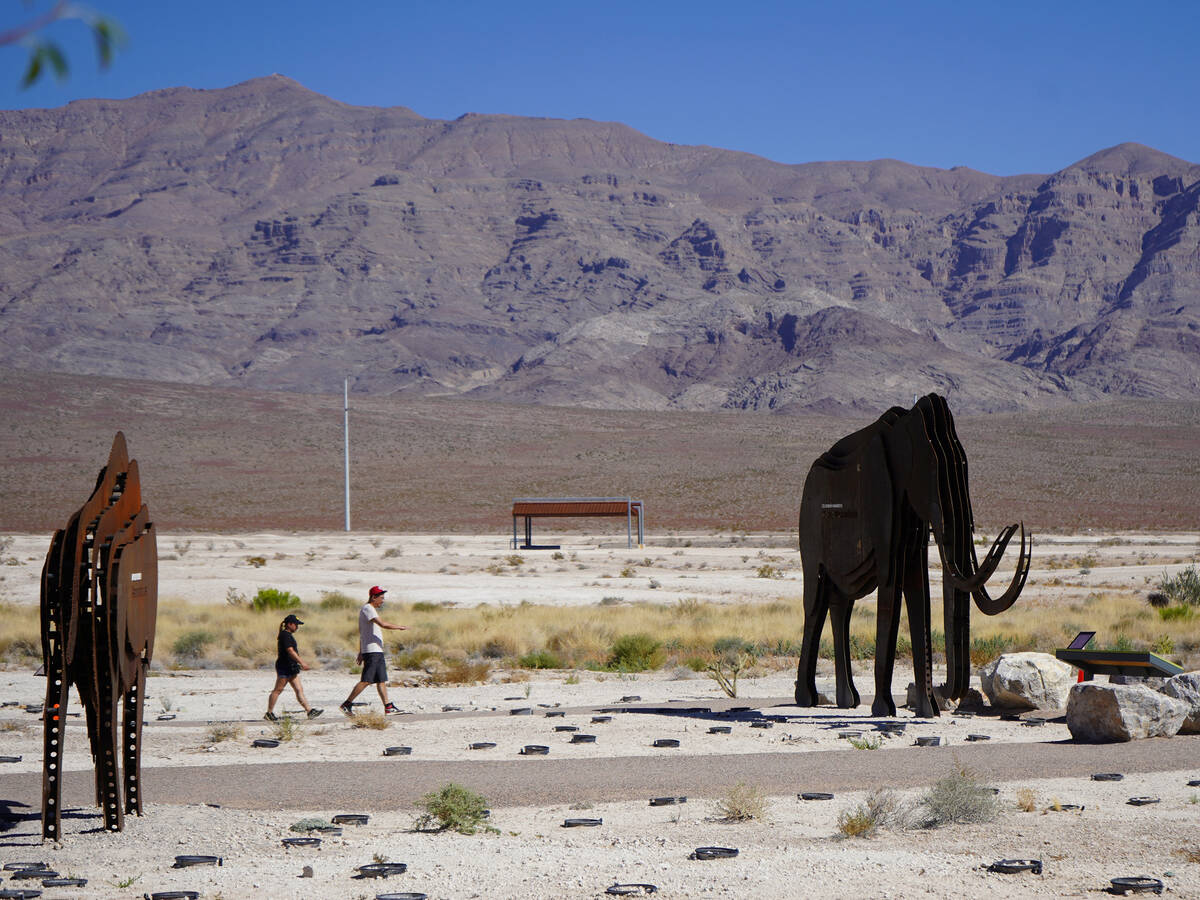 Park visitors walk among life-sized artistic depictions of Pleistocene animals such as the Colu ...