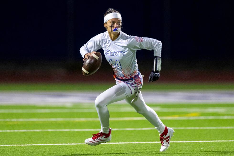 Liberty senior Kaylie Phillips (14) looks to throw the ball during the high school flag footbal ...