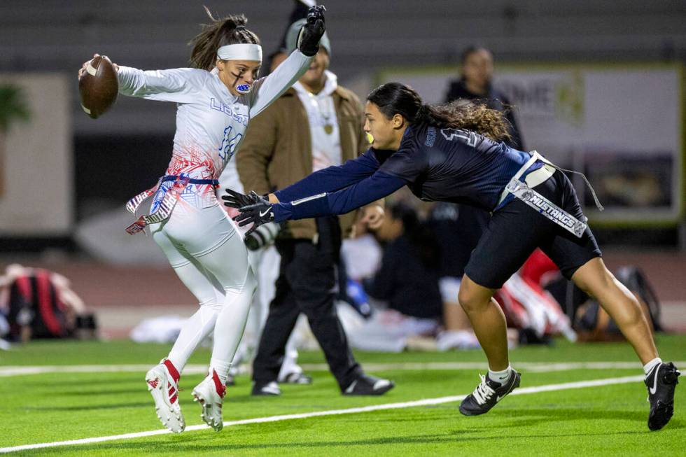 Liberty senior Kaylie Phillips, left, avoids Shadow Ridge junior Jaylani Palmer, right, during ...