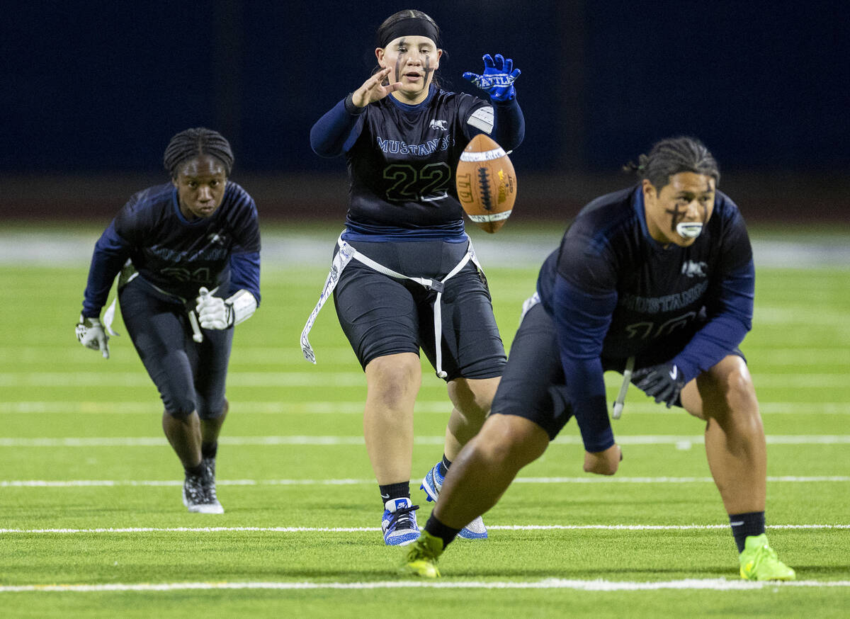 Shadow Ridge junior Isabella Turo, right, snaps the ball to senior Aubree Davis (22) during the ...