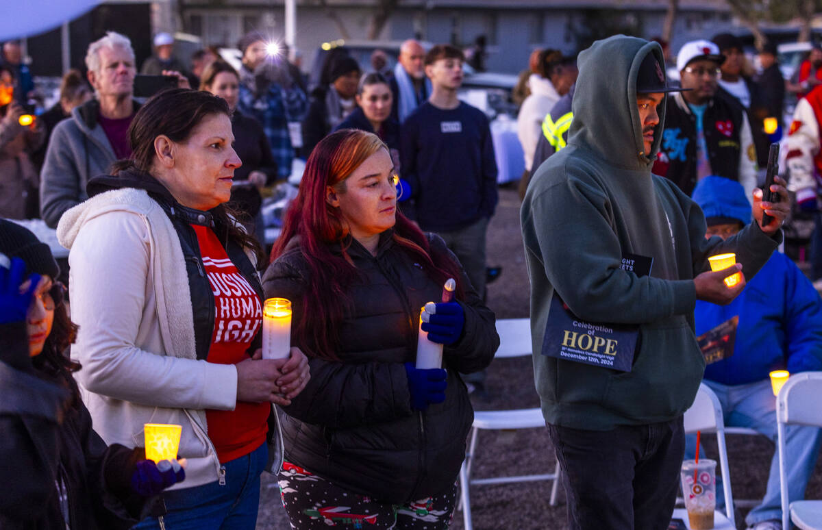 Attendees hold their lit candles as the names of those lost this year a read during the 31st Ho ...