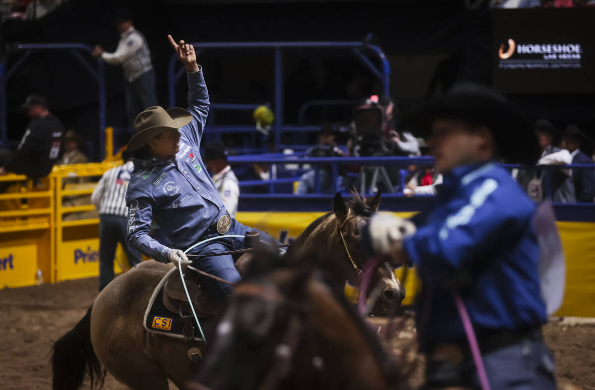 Kaleb Driggers, right, and Junior Nogueira celebrate after competing in team roping during the ...