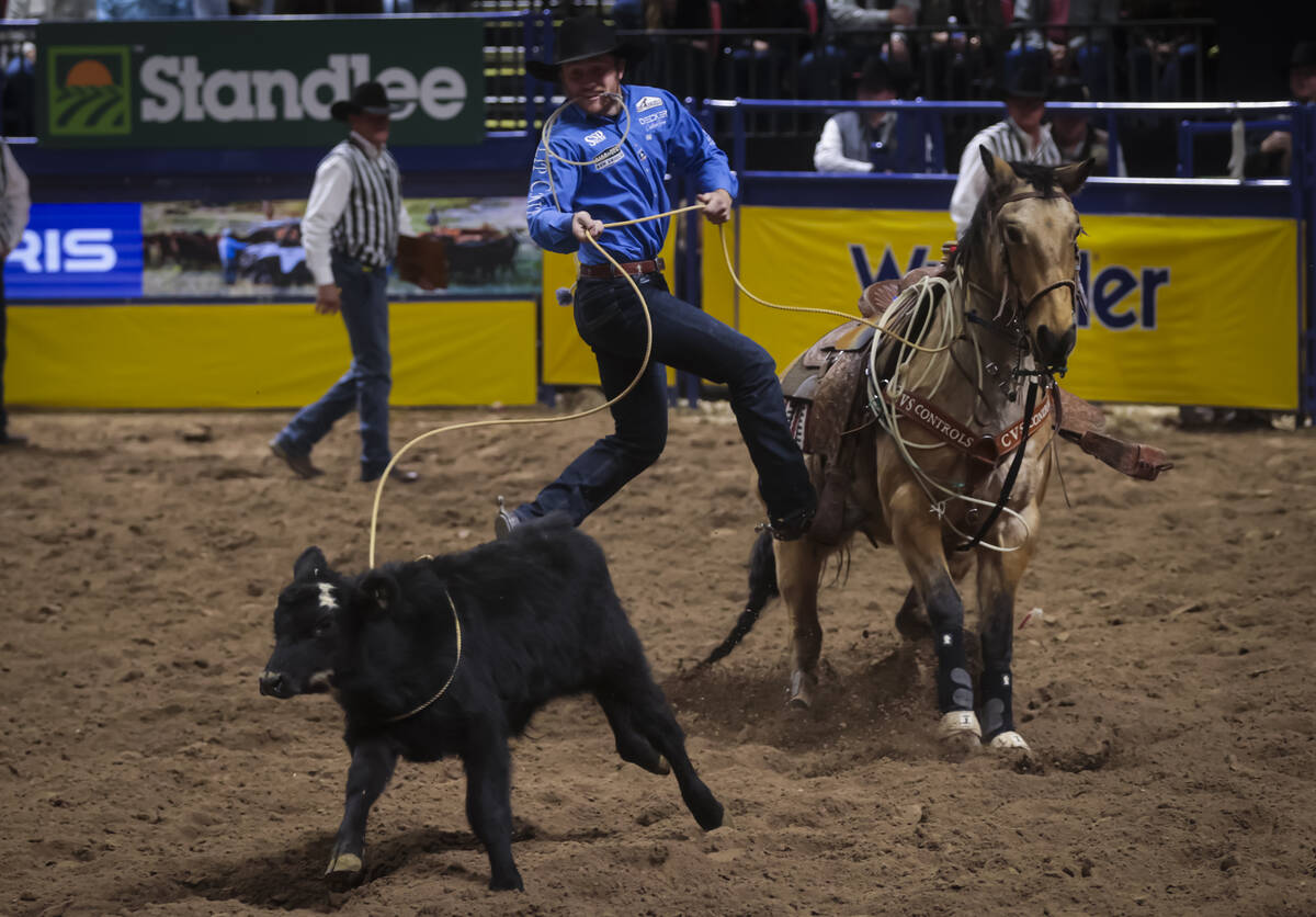 Joel Harris competes in tie-down roping during the 8th go-round of the National Finals Rodeo at ...