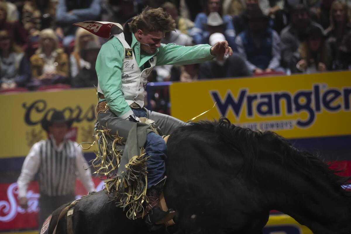 Cooper Cooke competes in bareback riding during the 8th go-round of the National Finals Rodeo a ...