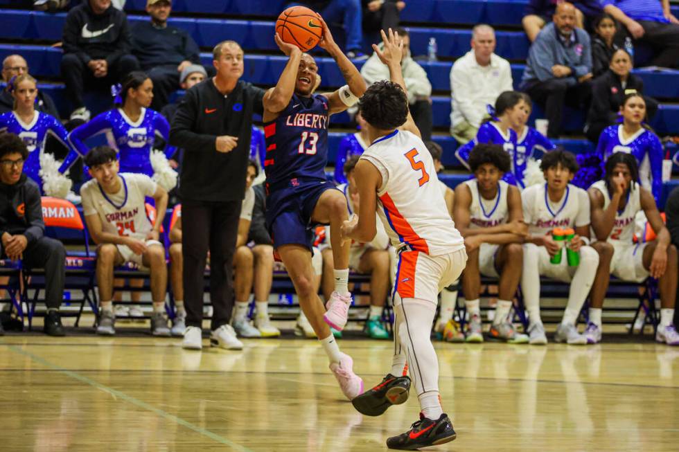 Liberty point guard Jaden Riley (13) passes the ball to an open teammate during a basketball ga ...