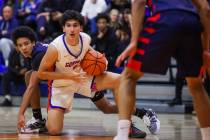 Bishop Gorman guard Dino Roberts (5) looks for an open teammate as he struggles to keep hold of ...