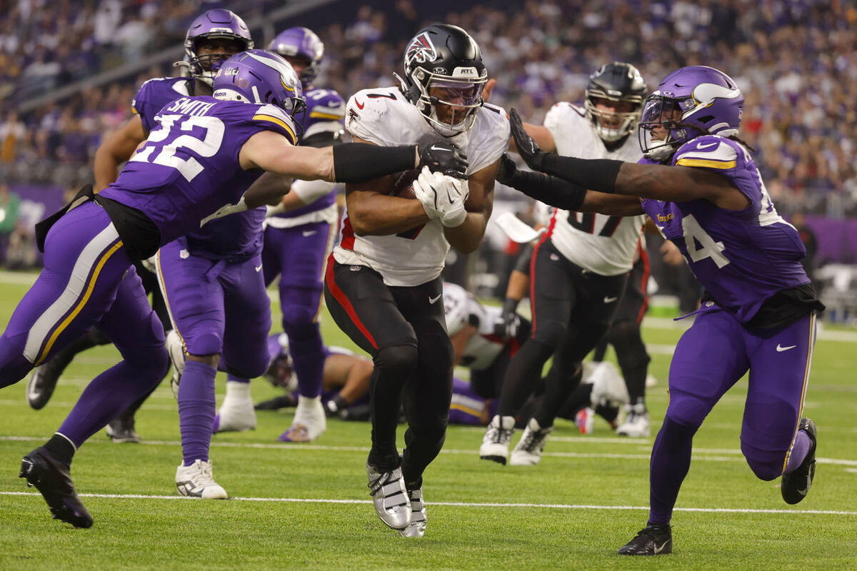 Atlanta Falcons running back Bijan Robinson (7) scores on a 13-yard touchdown run between Minne ...