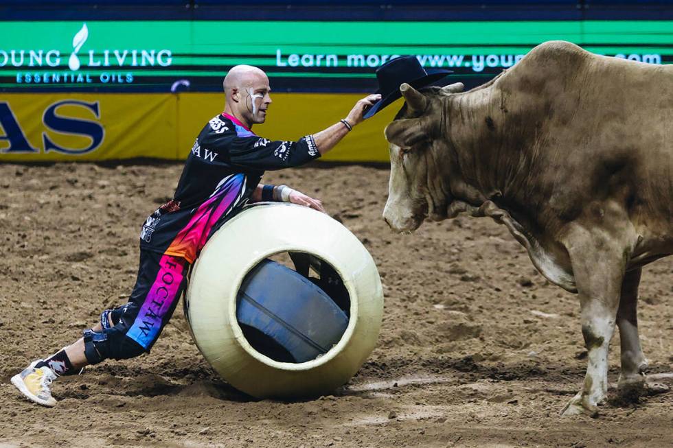 Bullfighter Dusty Tuckness offers his hat to one of the bulls after Josh Frost’s ride du ...