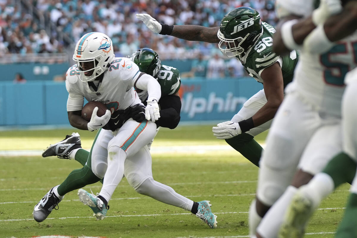 Miami Dolphins running back De'Von Achane (28) is tackled by New York Jets defensive end Solomo ...