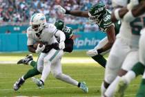 Miami Dolphins running back De'Von Achane (28) is tackled by New York Jets defensive end Solomo ...