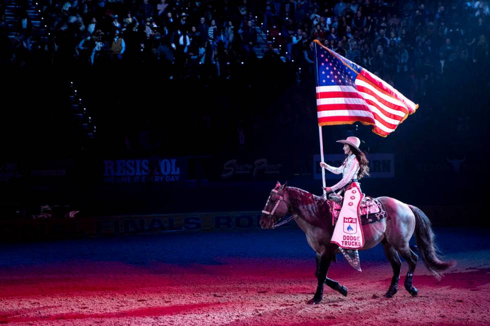 The American flag is presented before day nine of the National Finals Rodeo at the Thomas & ...