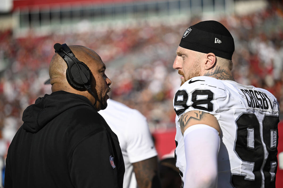 Las Vegas Raiders head coach Antonio Pierce, left, works with defensive end Maxx Crosby (98) on ...