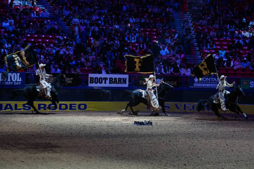 Cowgirls ride into the arena with NFR flags during the final night of National Finals Rodeo at ...