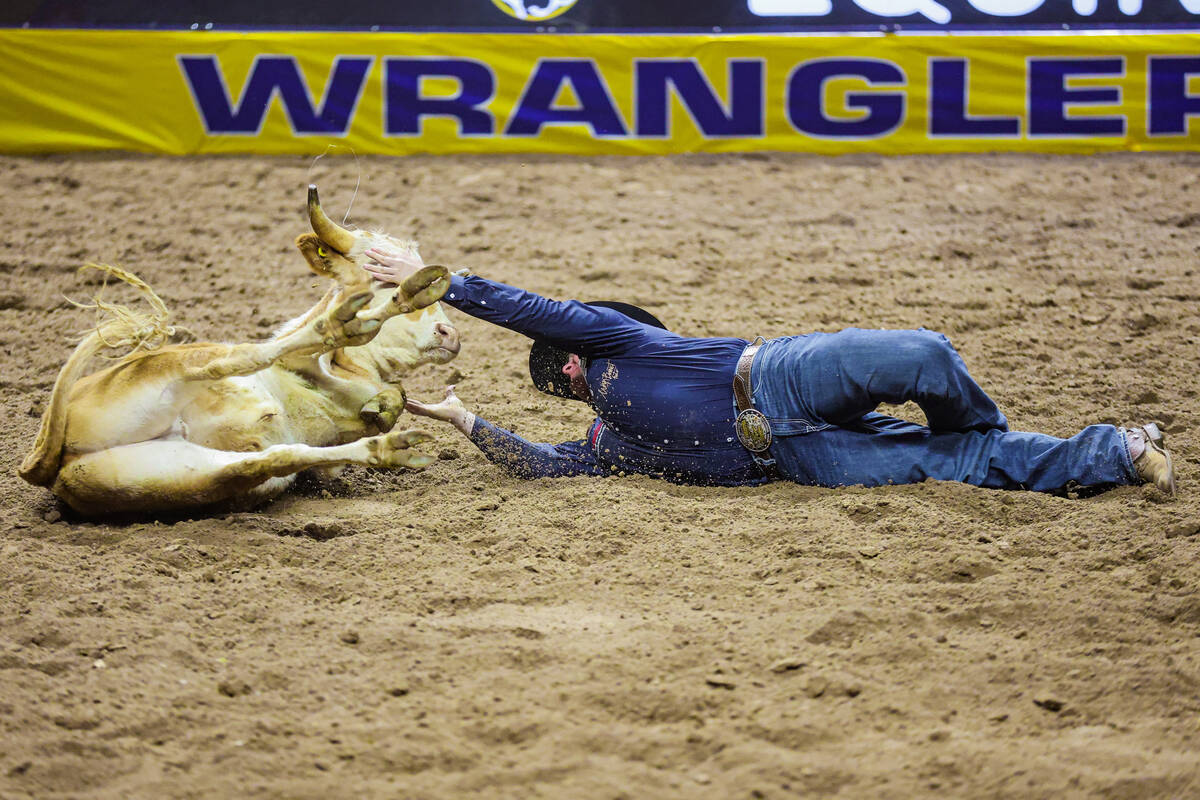 Steer wrestler Cash Robb reaches for the steer during the final night of National Finals Rodeo ...