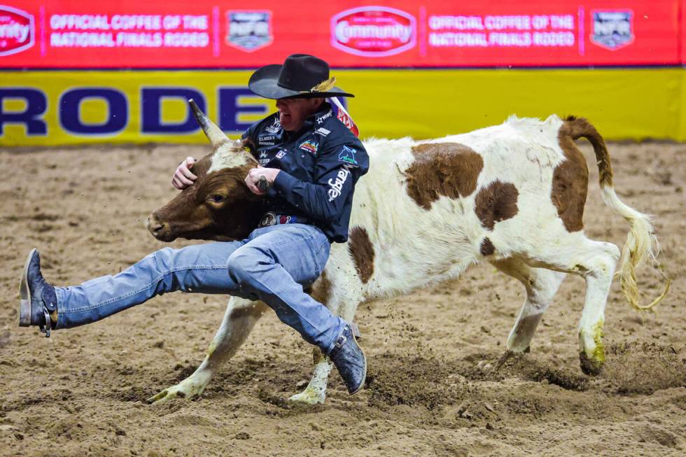 Steer wrestler Dalton Massey tries to force the steer down during the final night of National F ...