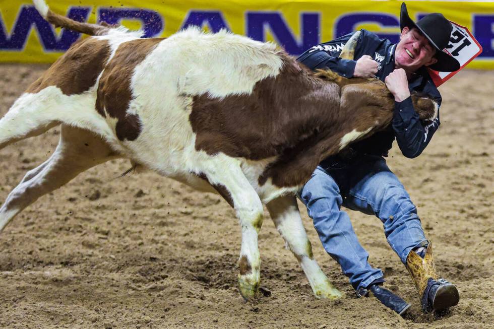 Steer wrestler Dalton Massey tries to force the steer down during the final night of National F ...