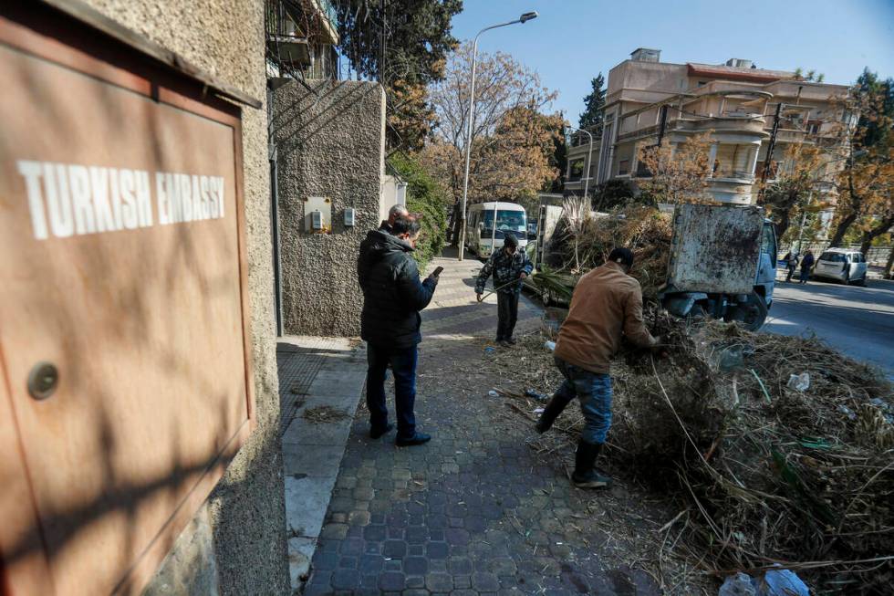 Workers clean outside the Turkish embassy in Damascus, Syria, Saturday, Dec. 14, 2024. (AP Phot ...