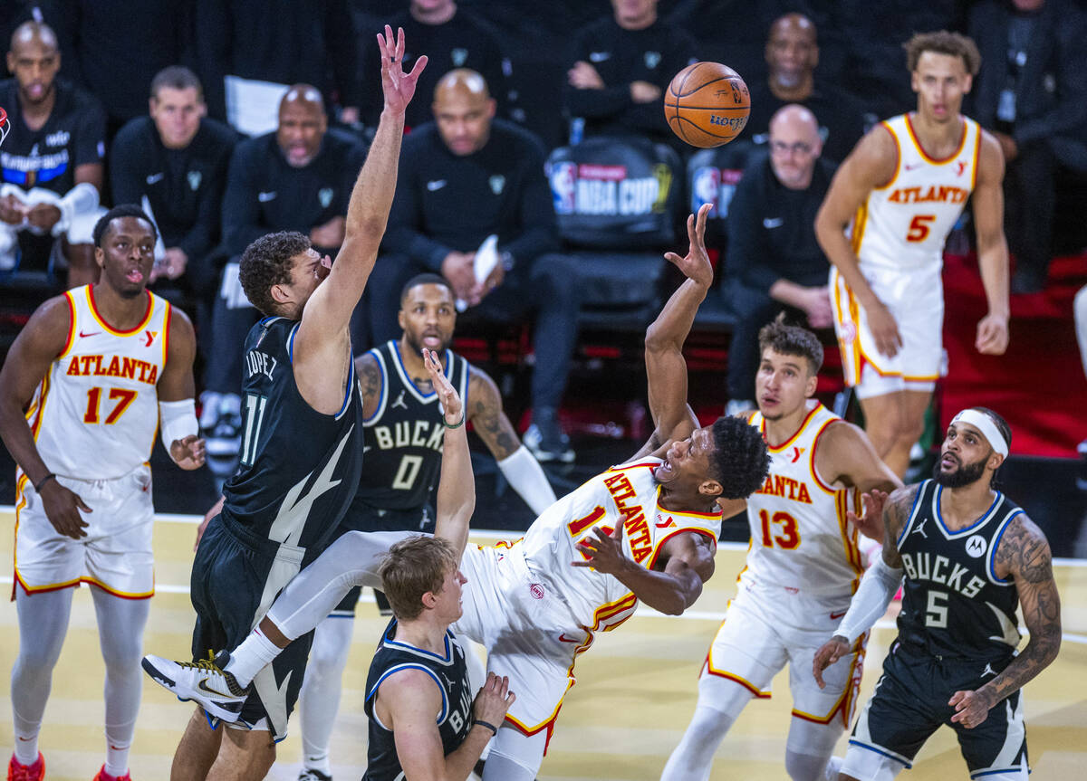 Atlanta Hawks forward De'Andre Hunter (12) gets off a shot while falling back with Milwaukee Bu ...